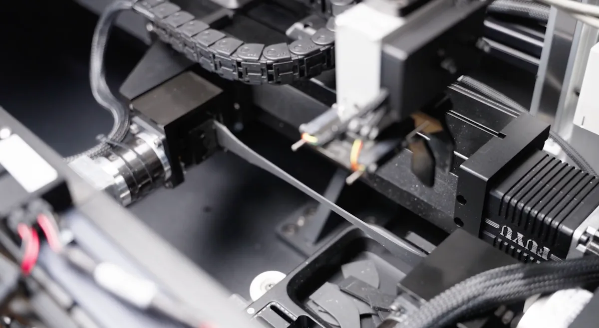 Close-up view of the intricate internal mechanism and wiring of a LabsCubed automated tensile testing machine, showing precision engineering.